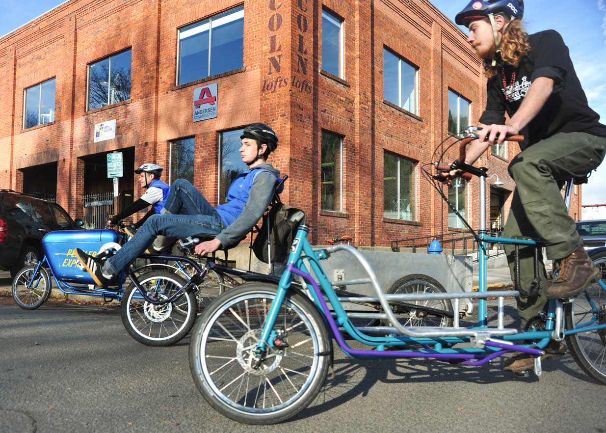 Three bicycle couriers providing local delivery in Eugene, OR